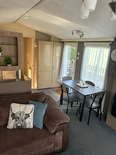 The corner sofa in The Lake District Caravan with a Highland cow cushion.